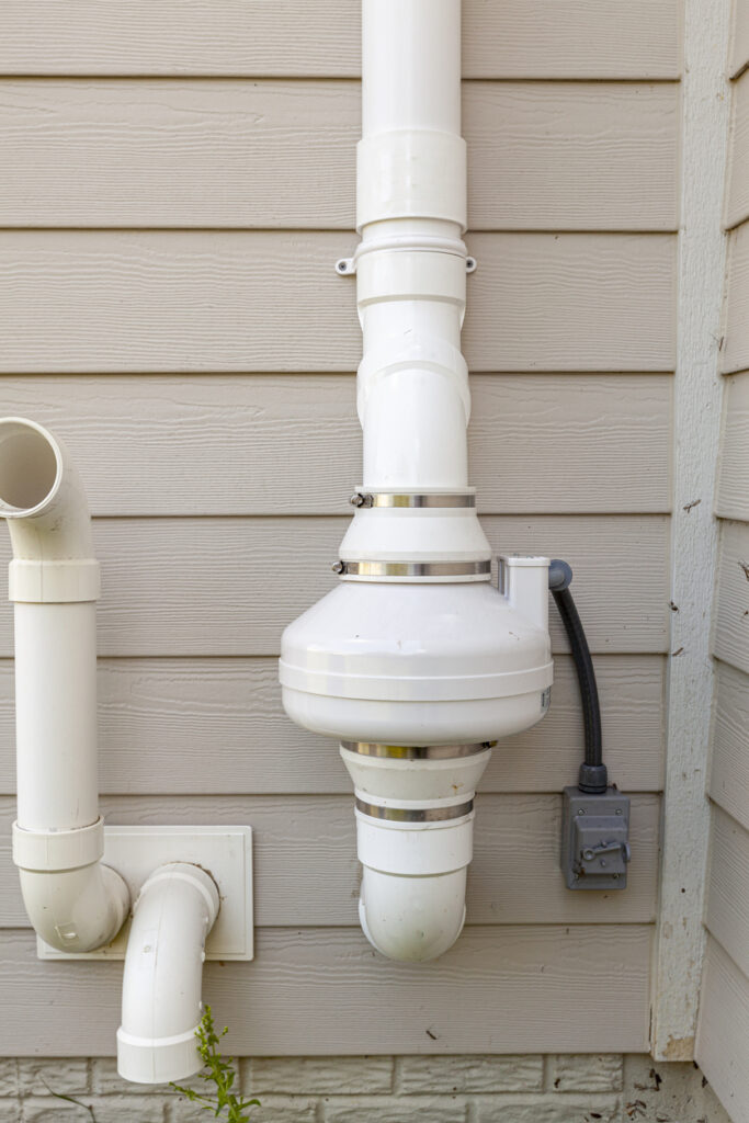 Radon mitigation system attached to a house