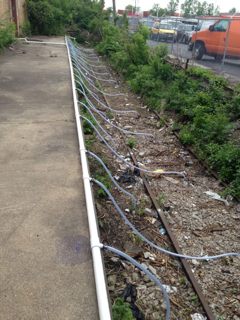 In-situ soil remediation injection piping installed between active railroad tracks to treat contamination without excavation.