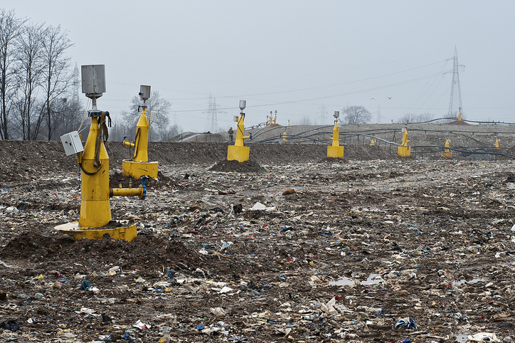 Landfill gas collection system wellfield showing yellow vertical extraction wells connected to black lateral piping.